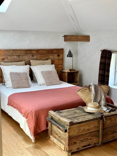 une chambre avec un grand lit avec une tête de lit en bois dans l'établissement La Ferme du Miouat, à Saint-Julien-en-Born
