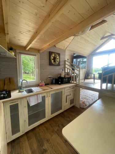 a kitchen with a sink and a large window at Tiny house du Château du Boulay-Morin in Le Boulay-Morin