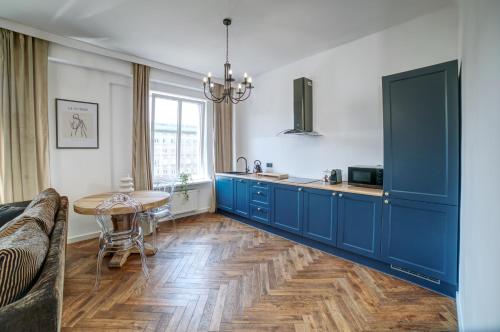 une cuisine avec des armoires bleues et une table dans l'établissement Marszałkowska Move in Premium apartament no 1, à Varsovie
