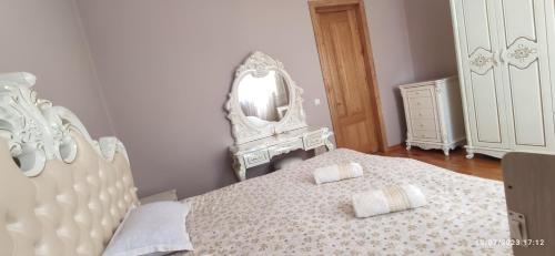 a white bedroom with a bed and a mirror at Chateau Bagdati in Nerget'i