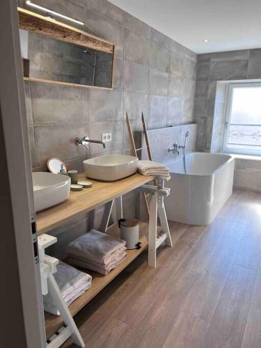 une salle de bain avec deux lavabos et une baignoire dans l'établissement Gîte Anna, à Chavanay