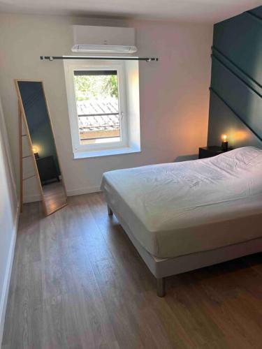 une chambre avec un lit, une fenêtre et un miroir dans l'établissement Gîte Anna, à Chavanay