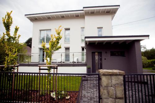 a white house with a black fence at Willowa NO. 5 APARTAMENTS in Wisła