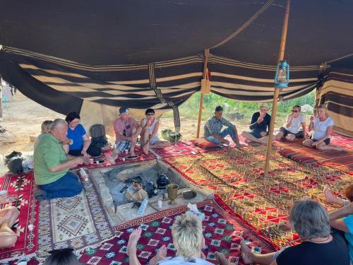 a group of people sitting under a tent at Grandma's house in Wadi Musa