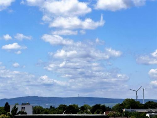 a blue sky with clouds and a wind turbine at Panorama Penthouse Apartment mit Klima und Whirlpool für bis zu 6 Personen in Frankenthal
