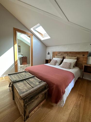 a bedroom with a large bed with a red bedspread at La Ferme du Miouat in Saint-Julien-en-Born