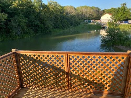 una terraza de madera con vistas al río en Glamping pod, seven acre farm campsite en Lincoln