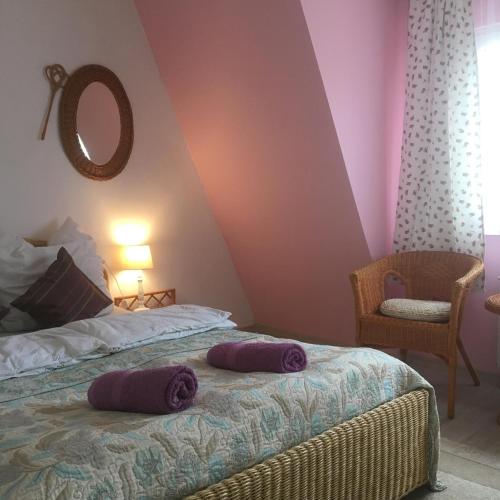 two purple pillows on a bed in a bedroom at Agroturystyka Chłopy in Sarbinowo
