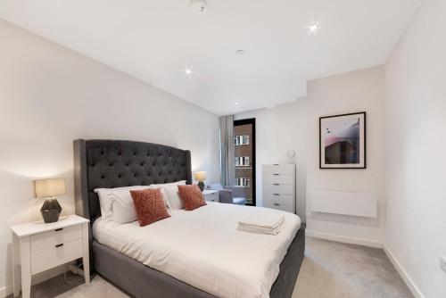 1 Bedroom Close to Tower Hill في لندن: غرفة نوم مع سرير كبير مع اللوح الأمامي الأسود