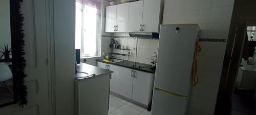 a kitchen with white cabinets and a refrigerator at katyra house in Aubervilliers