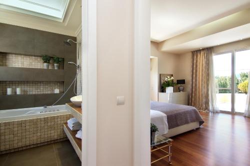1 dormitorio con 1 cama y baño con bañera en Villa Sabia en Vari
