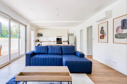 a living room with a blue couch and a kitchen at Villa Constance - Antibes in Antibes