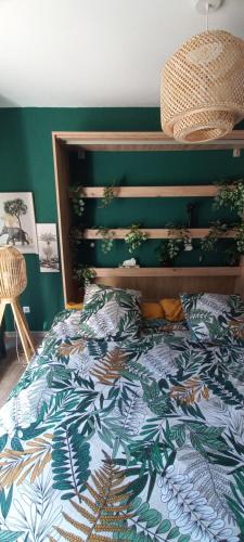 una camera da letto con un letto con una parete verde di Chambre indépendante piscine en saison petit déjeuner inclus a Véretz