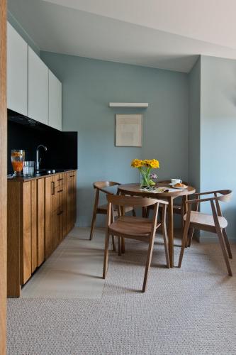 a dining room with a table and a kitchen at Palanga Visit Apartments and SPA in Palanga