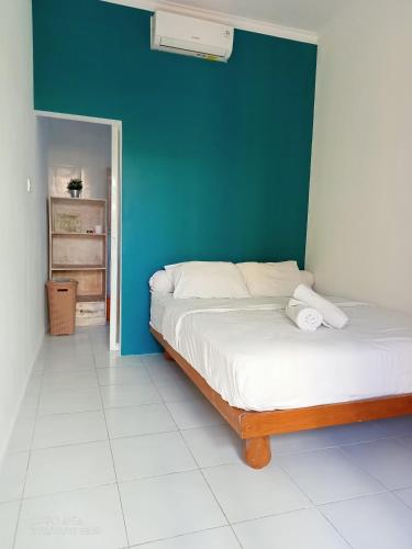 una camera con letto e parete blu di Pondok Ayu Homestay a Canggu