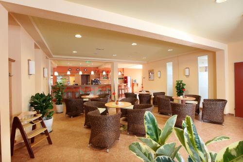 um restaurante com mesas, cadeiras e plantas em JUFA Hotel St Michael im Lungau em Sankt Michael im Lungau