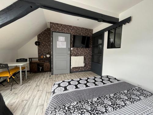 a bedroom with a bed and a brick wall at Chambres d'hôtes à la forge du Coglais in La Selle-en-Coglès