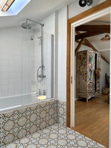 a bathroom with a bath tub and a shower at La Ferme du Miouat in Saint-Julien-en-Born