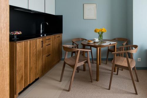 a kitchen with a table with chairs and a sink at Palanga Visit Apartments and SPA in Palanga