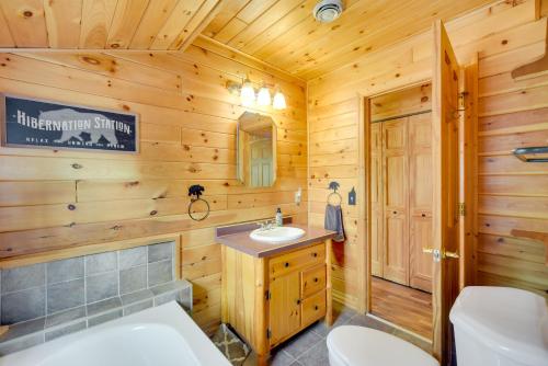 a log cabin bathroom with a sink and a toilet at Lakefront Wisconsin Home - Deck, Fire Pit and Kayaks in Stone Lake