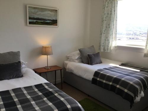 two beds in a room with a window at Rhuside in Campbeltown
