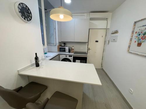 une cuisine avec un comptoir blanc, une table et des chaises dans l'établissement Stylish one bedroom flat in the heart of Madrid, à Madrid