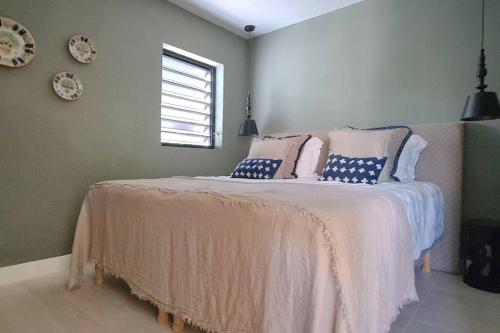 a bedroom with a large bed with blue and white pillows at Boutique appartment 4P with PRIVATE POOL, near Jan Thiel & Mambo beach in Willemstad