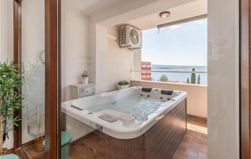 a bath tub in a bathroom with a large window at Nice Apartment In Dramalj With House Sea View in Dramalj