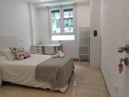 een witte slaapkamer met een bed en een raam bij Apartment in Bilbao, comfortable and well equipped in Bilbao