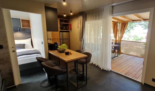Cette chambre dispose d'une table, d'un lit et d'un balcon. dans l'établissement Mobile home Luka, à Kruševo