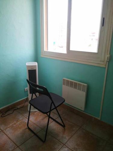 une chaise dans une pièce avec fenêtre et radiateur dans l'établissement Chambre privée dans un appartement pour 1 personne, à Toulon