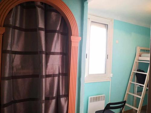 une pièce avec un rideau, une fenêtre et une chaise dans l'établissement Chambre privée dans un appartement pour 1 personne, à Toulon