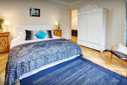 een slaapkamer met een groot bed en een blauw tapijt bij Manoir de Leschaux - OVO Network in Le Petit-Bornand-lès-Glières