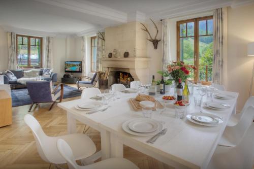 een eetkamer met een tafel en stoelen en een open haard bij Manoir de Leschaux - OVO Network in Le Petit-Bornand-lès-Glières