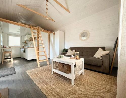 a living room with a couch and a ladder at Oak Heart, Lucavsalas namiņš in Rīga
