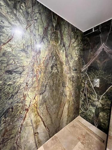 La salle de bains est pourvue d'un mur en pierre orné d'une peinture murale. dans l'établissement Apartament Maria Novum Residence, à Olimp
