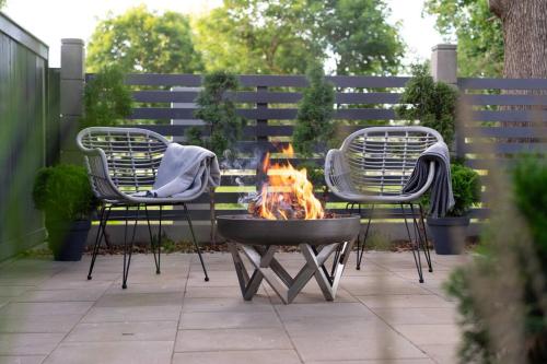 two chairs and a fire pit in a yard at Oak Heart, Lucavsalas namiņš in Rīga