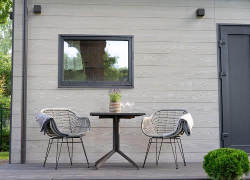a table and two chairs sitting next to a building at Oak Heart, Lucavsalas namiņš in Rīga
