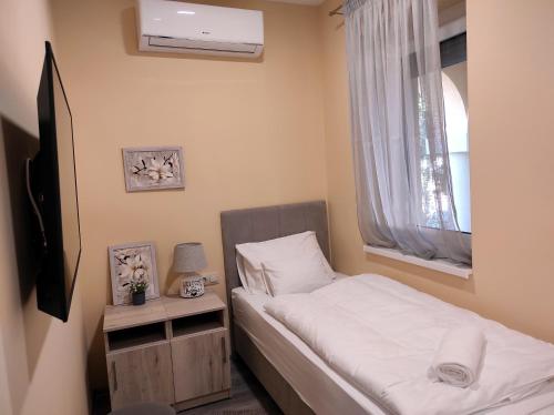 a small bedroom with a bed and a window at Villa Grácia in Badacsonytomaj