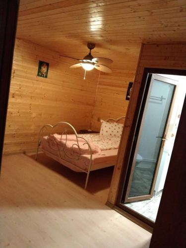una camera con un letto in una cabina di legno di Casa Delia a Vadu
