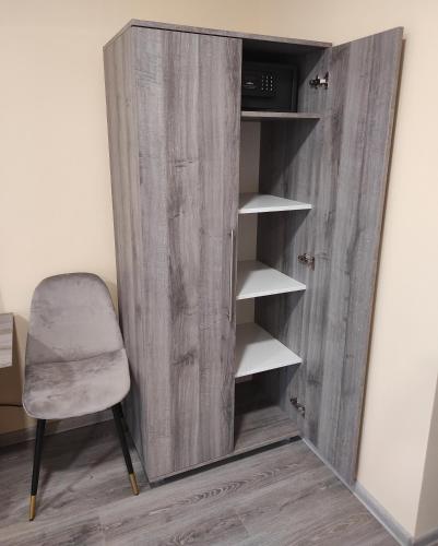 a wooden cabinet with a chair next to a wall at Villa Grácia in Badacsonytomaj