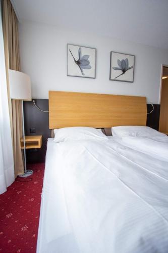 a hotel room with a bed and two pictures on the wall at City Hotel in Brunnen