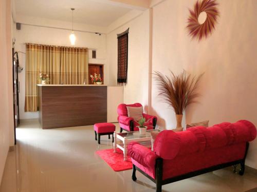 a living room with a red couch and two chairs at The Sanduk Homestay in Rantepao