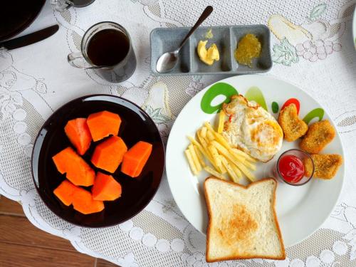 a table with a plate of food with eggs bread and vegetables at The Sanduk Homestay in Rantepao