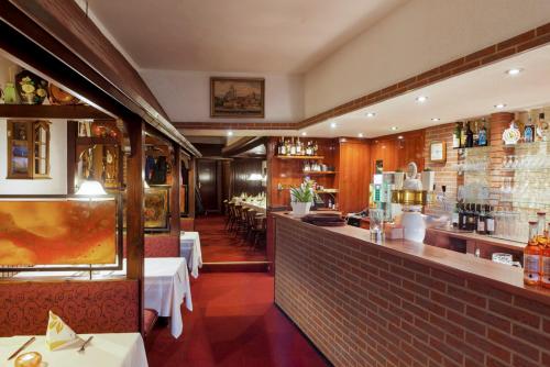 un restaurante con un bar con mesas y sillas en Restaurant Donau, en Hannover