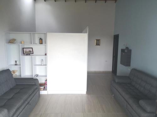 a living room with two couches and a sliding glass door at Villa Namaste, Cabaña Namaste 1 in Curití