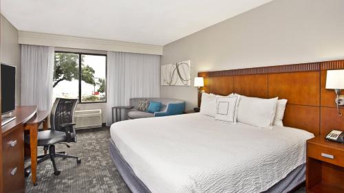 a hotel room with a bed and a desk at Courtyard by Marriott Gulfport Beachfront in Gulfport