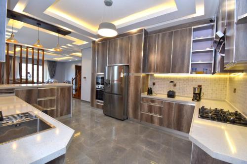 a large kitchen with a stainless steel refrigerator at Supreme Villa in Kigali
