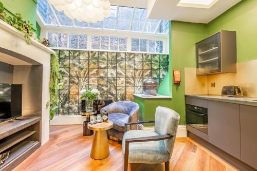 a kitchen with green walls and two chairs and a window at 34 Coney Street in York