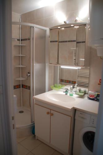 biała łazienka z umywalką i prysznicem w obiekcie Vue mer les Becs Saint Hilaire w mieście Saint-Hilaire-de-Riez